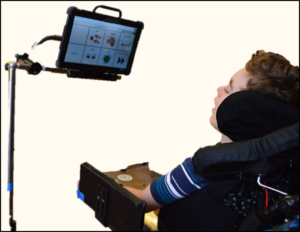 jeffrey, looking at the core vocabulary on a screen mounted to his wheel chair